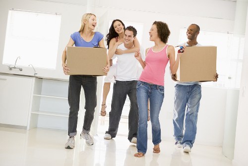 Moving team handling household boxes and furniture on an Islington street